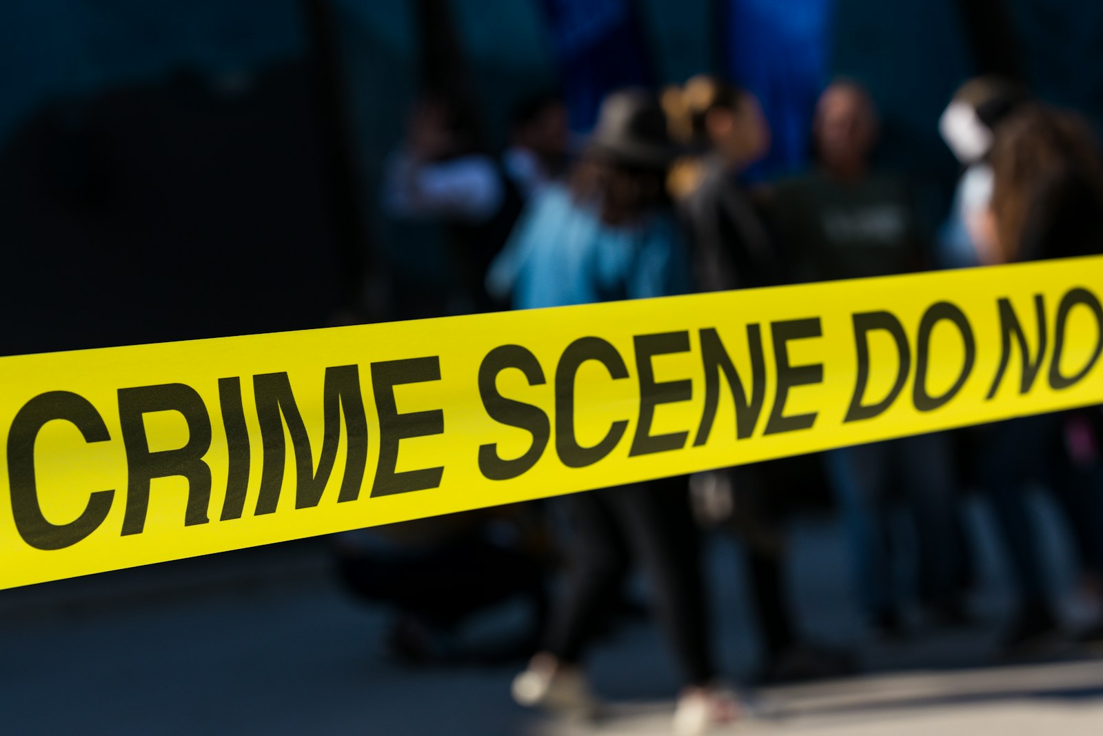 a group of people standing next to a yellow police line